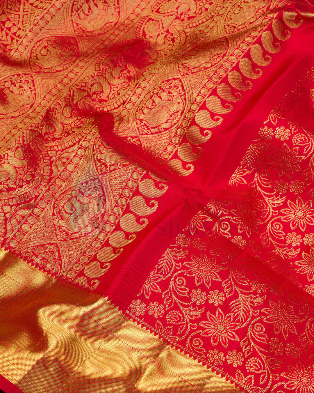 Close-up of red Kanjivaram silk saree showing floral zari design and gold border details