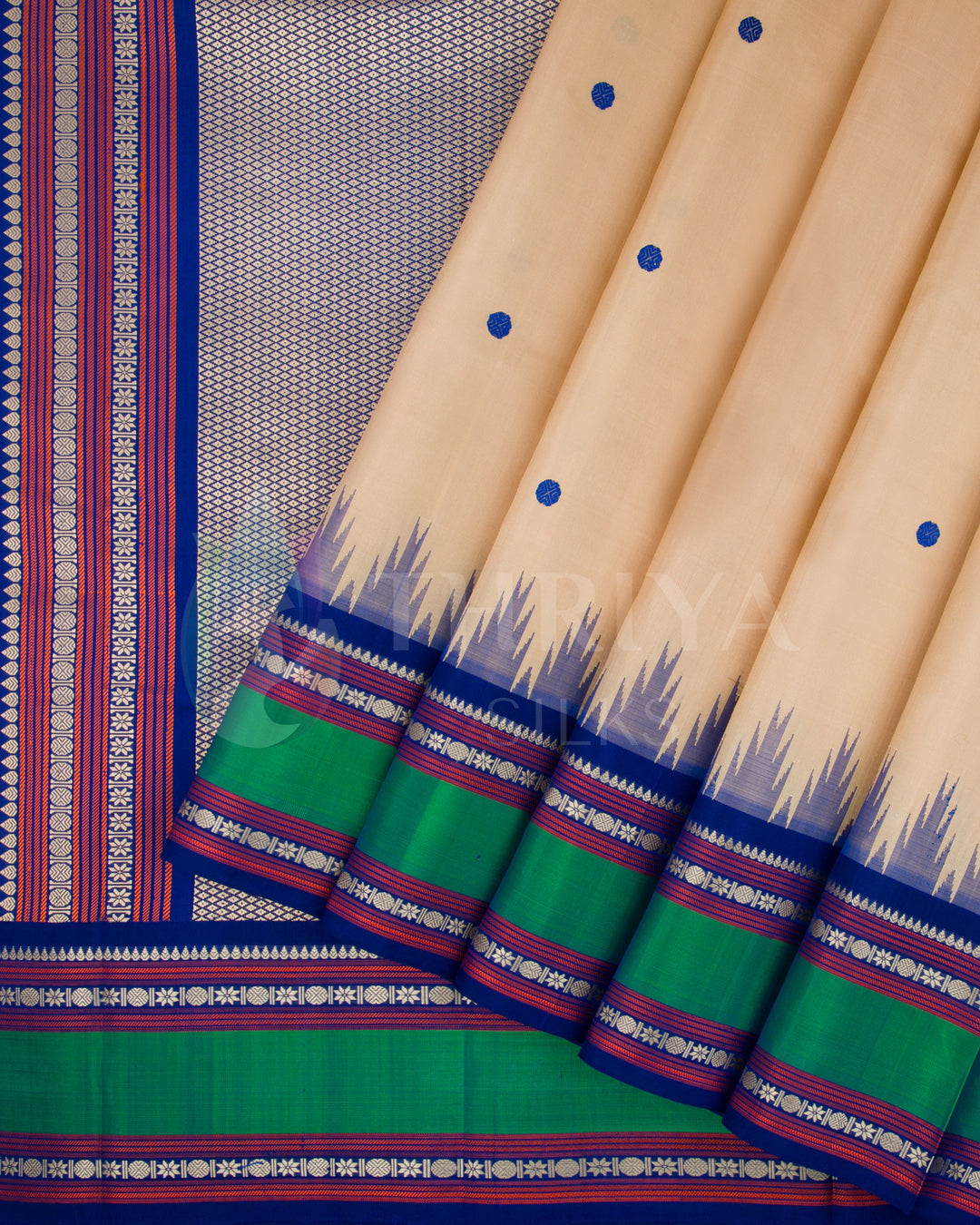 Beige silk saree with vibrant green border and rich blue zari work, from Thriya Silks
