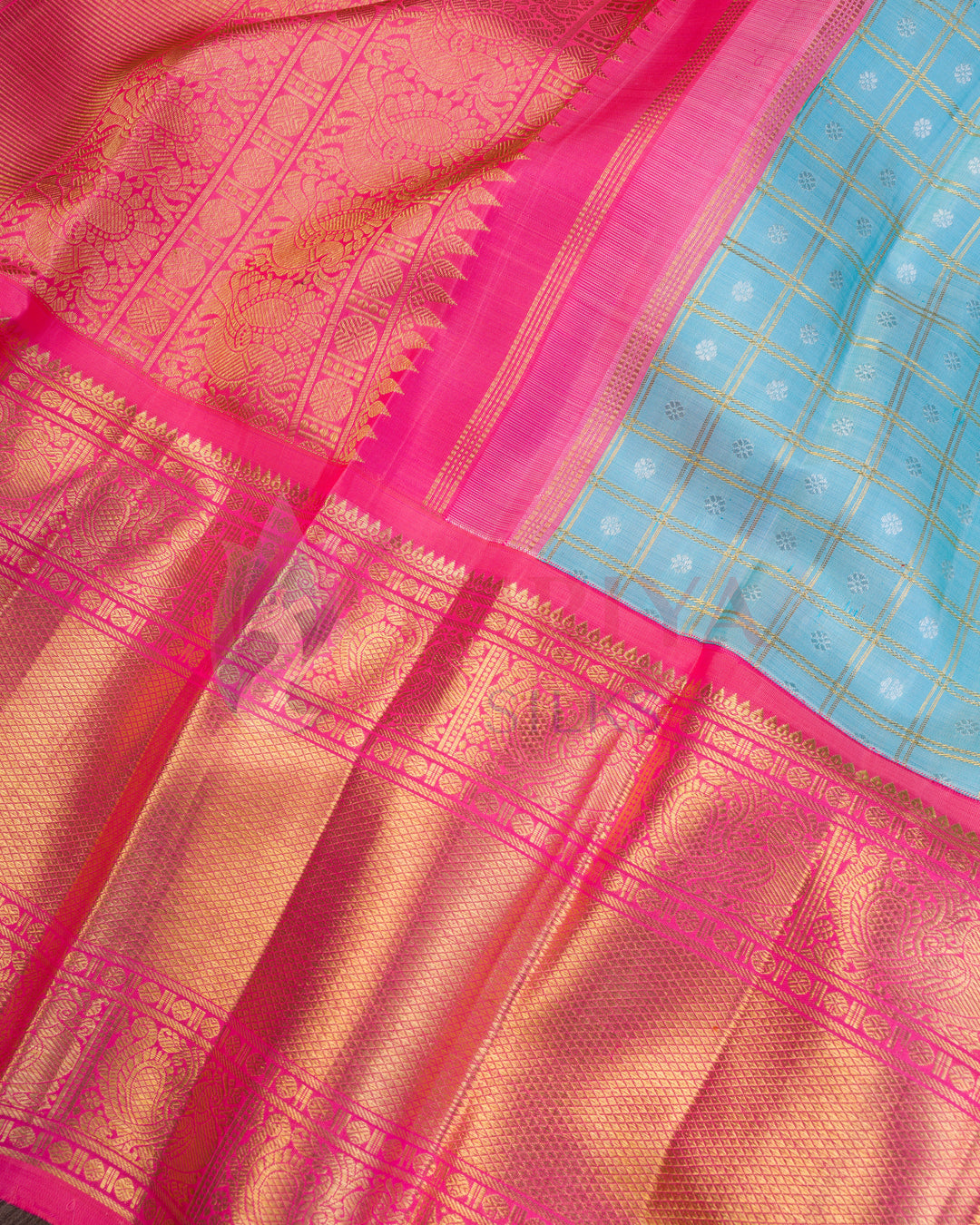 Sky blue pallu of Kanchipuram silk saree with pink border and intricate gold zari checks