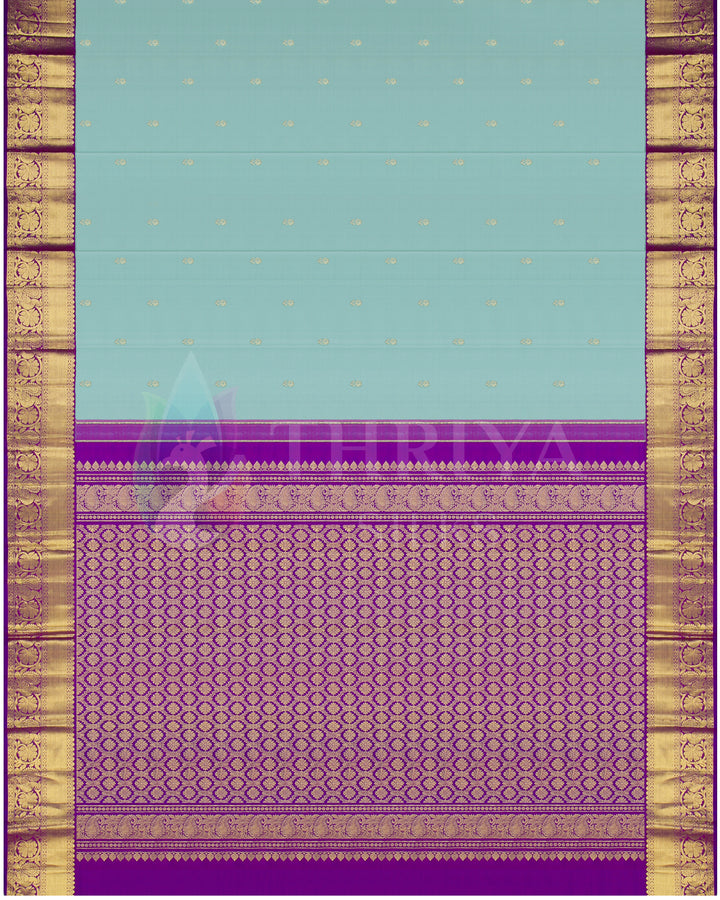 Full display of Thriya Kanchipuram saree with soft blue base, gold motifs, and richly woven purple zari pallu
