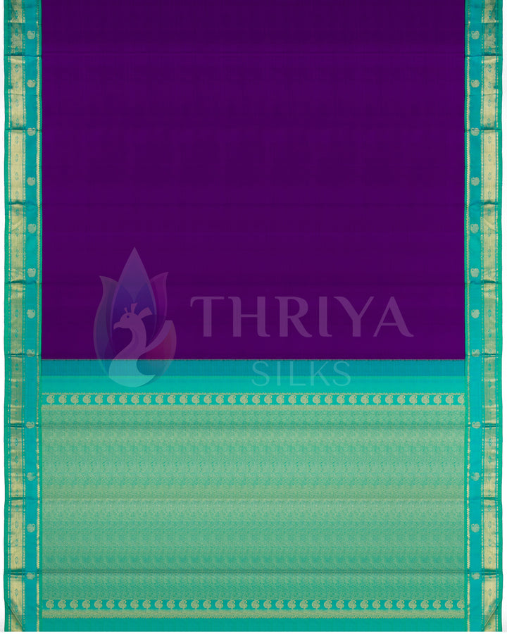 Full view of deep purple silk saree with aqua blue pallu and traditional gold zari design