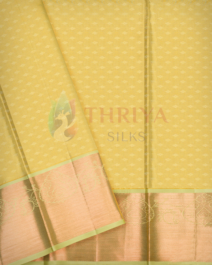Full-length golden yellow Kanjivaram silk saree with green border spread out to reveal intricate design and rich silk texture.