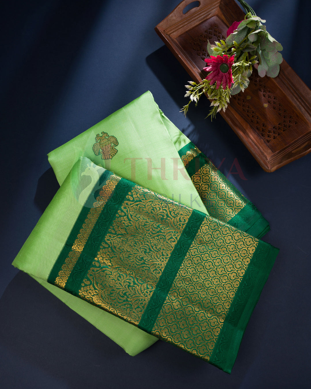 Light green Kanchipuram silk saree with gold floral buttas and intricately woven zari pallu