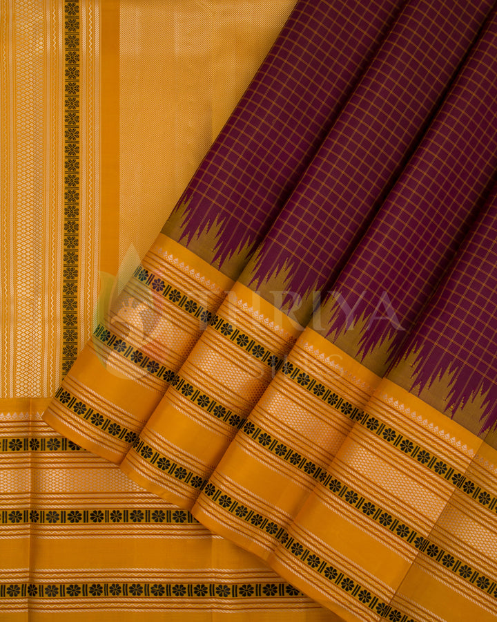 Maroon Kanjivaram silk saree featuring mustard yellow border and traditional zari pleats