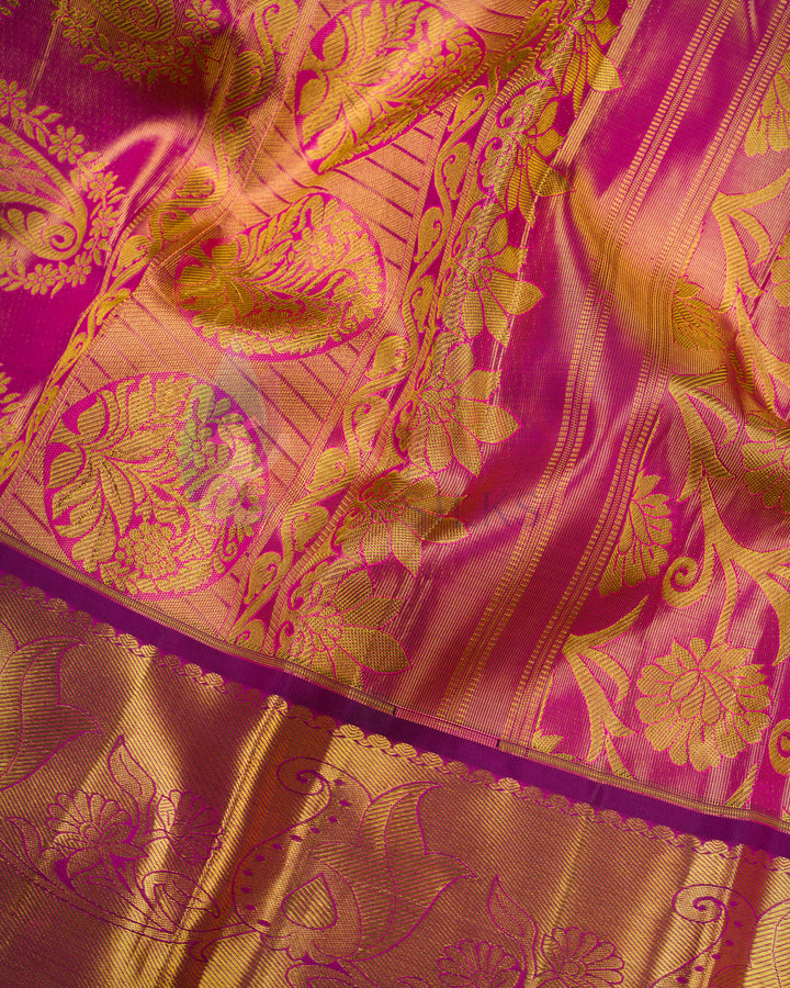 Close-up of luxurious gold zari work on magenta Kanjivaram silk fabric – pure silk saree texture