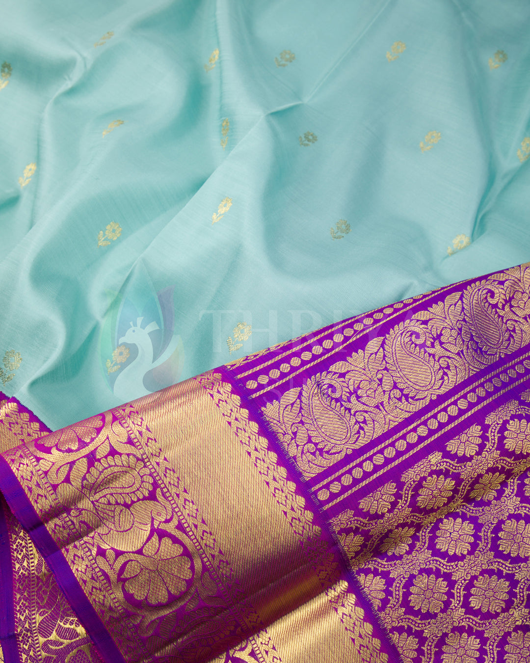 Detailed angle of pleats and pallu on Thriya silk saree featuring blue fabric and purple zari weaving
