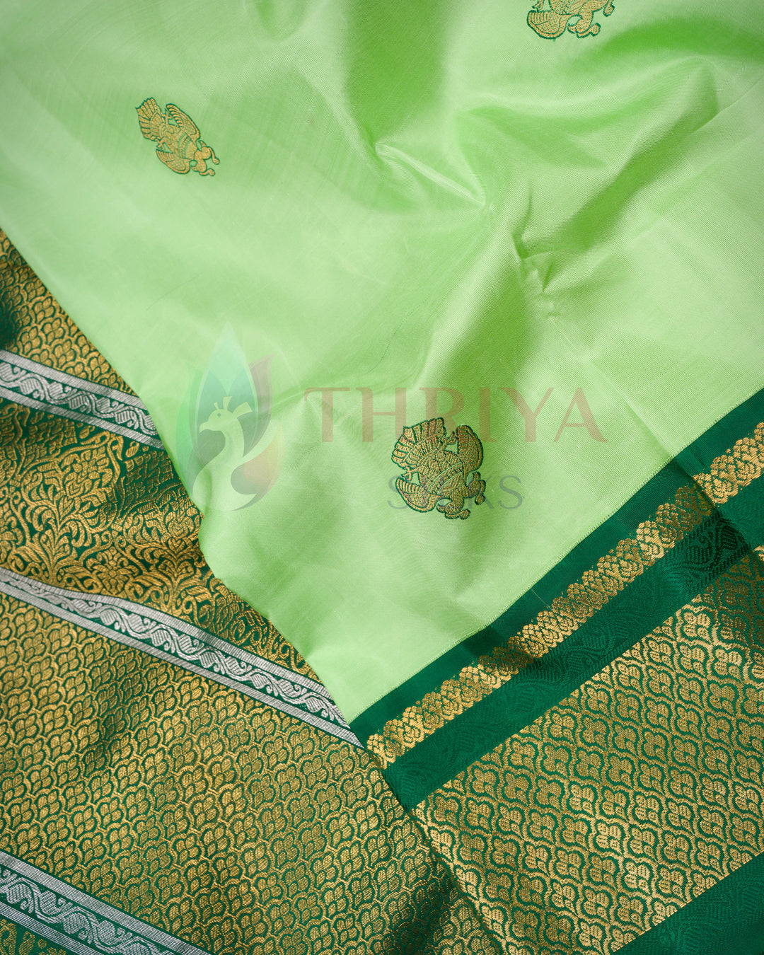 Traditional Kanchipuram silk saree in light green with gold zari border and buttas
