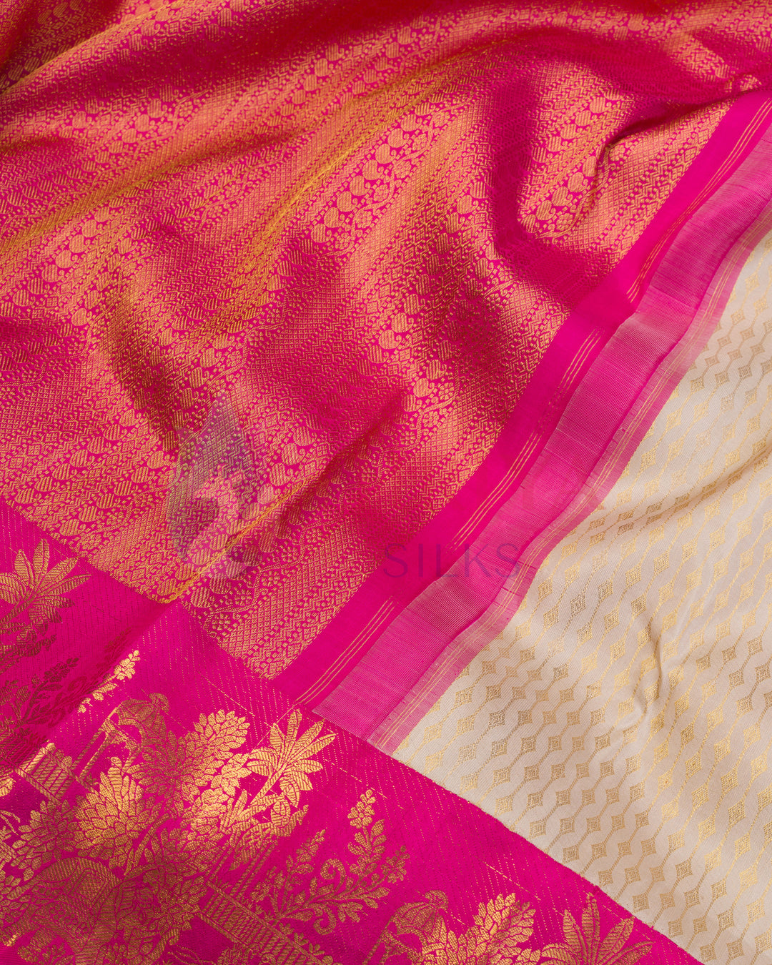 Close-up of vibrant pink zari temple border with golden floral weaving on off-white Kanjivaram silk saree