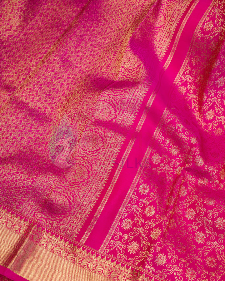 Close-up of floral zari pattern on rich pink silk saree with detailed pallu