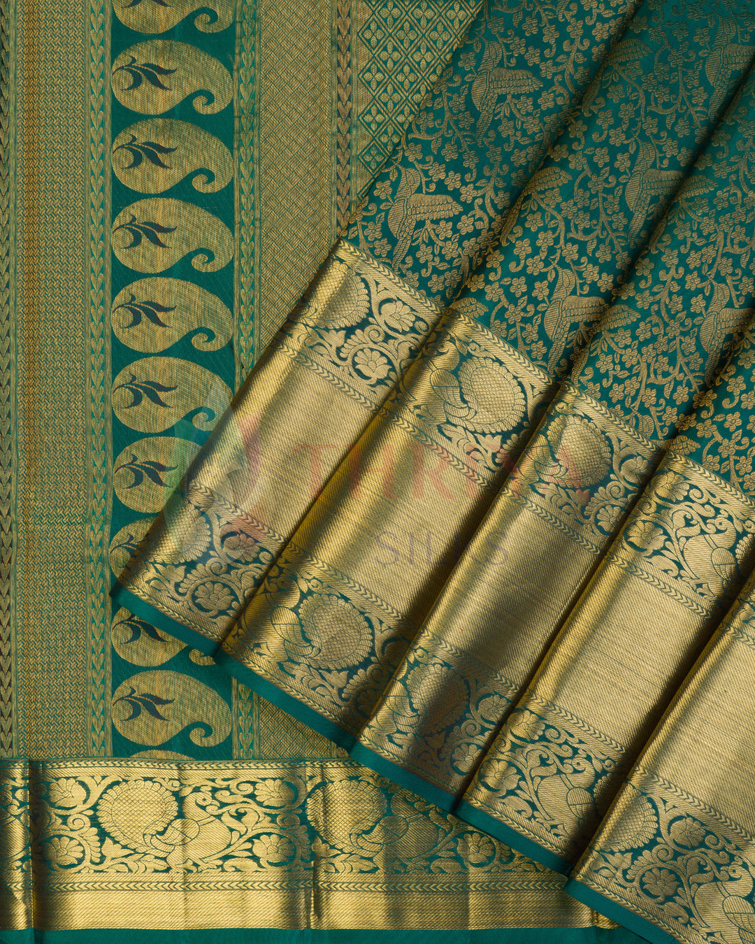 Green Kanjivaram silk saree with rich golden zari floral motifs and peacock border"