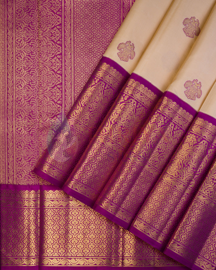 Close-up of cream and purple Kanjivaram silk saree with golden zari floral motifs and rich purple zari border