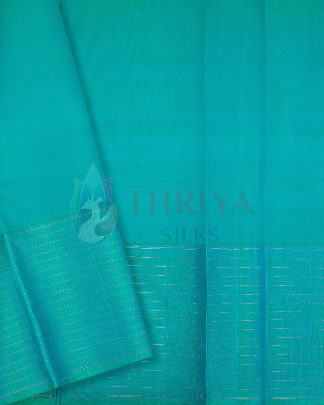 Green silk blouse piece with golden zari striped border complementing blue saree
