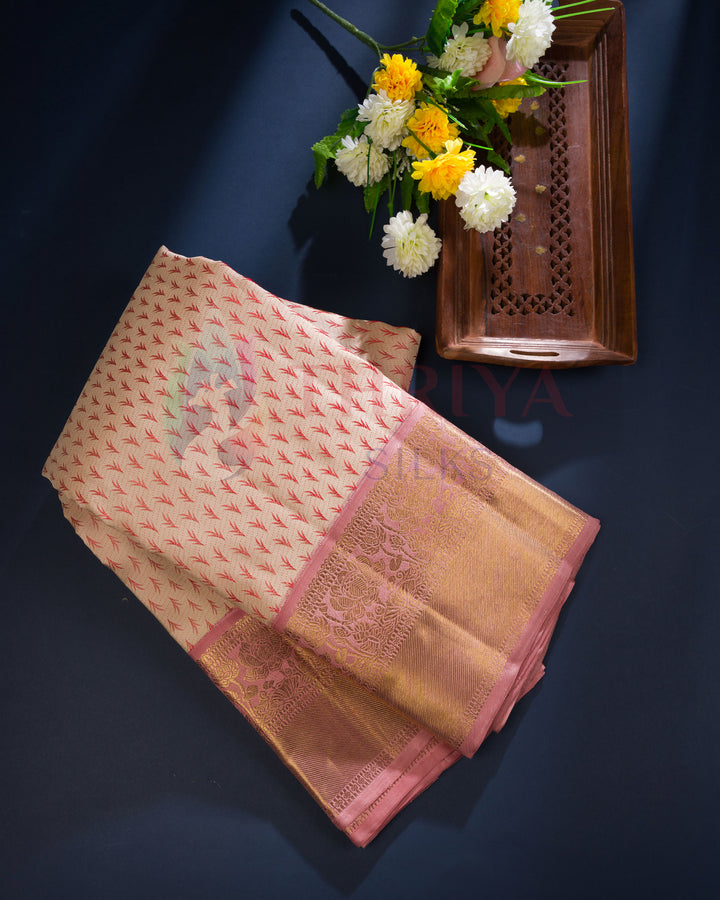 A woman gracefully posing in a traditional silk saree with gold zari detailing, showcasing the rich fabric and cultural charm.