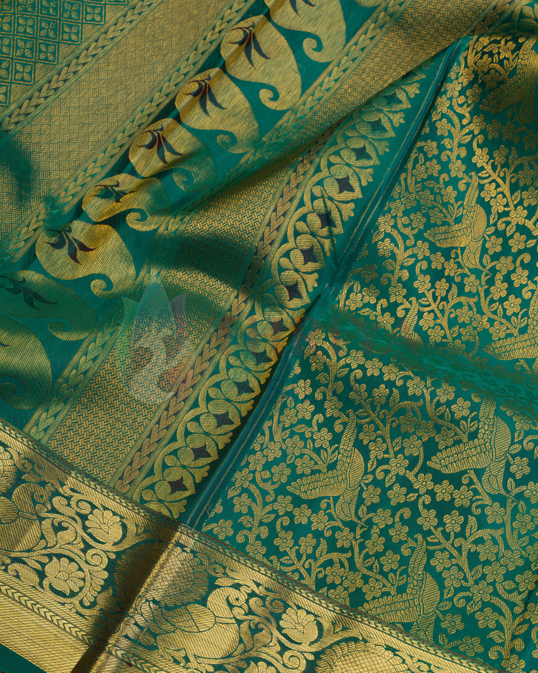Close-up of golden zari peacock motifs and floral vines on green Kanjivaram silk saree