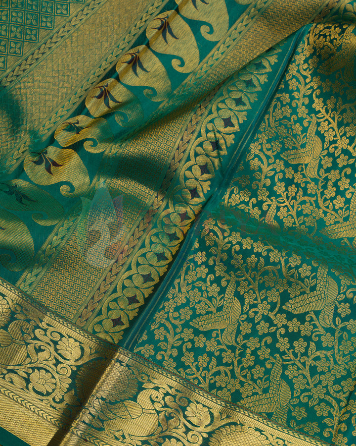 Close-up of golden zari peacock motifs and floral vines on green Kanjivaram silk saree