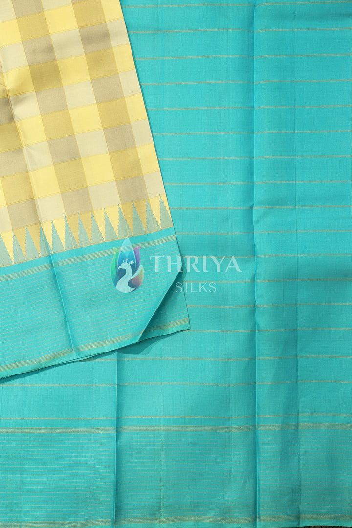Aqua blue silk saree with golden zari weave and yellow checked border.
