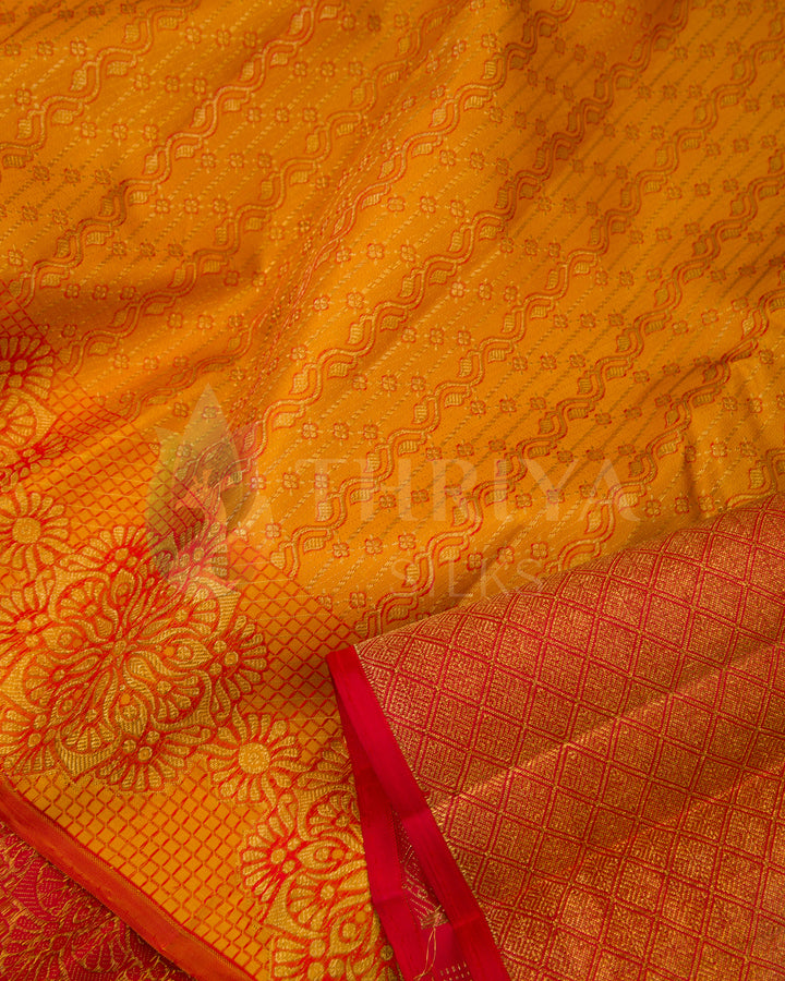 Detailed view of golden yellow Banarasi silk saree with gold zari motifs and red contrast border