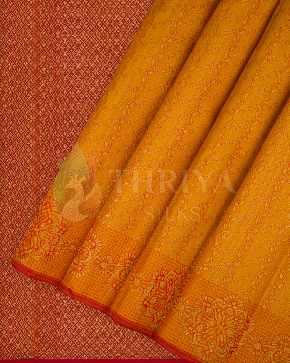 Pleated view of golden yellow Banarasi silk saree with red floral zari border and detailed texture