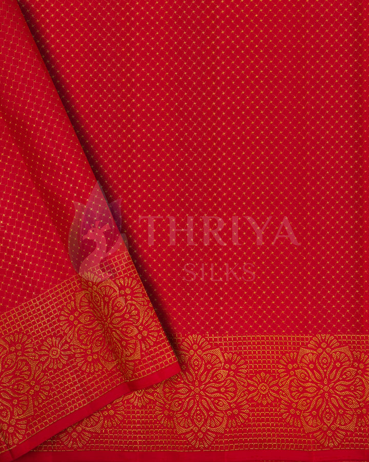 Close-up of red section from Banarasi silk saree featuring gold diamond buttas and floral zari border