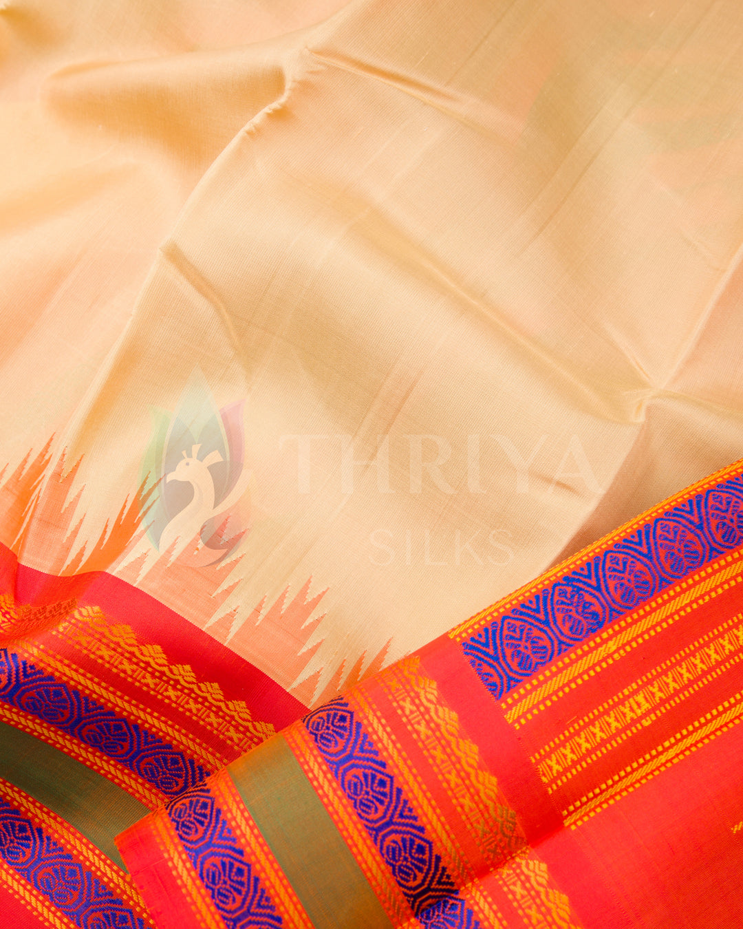 Close-up of beige silk saree body with contrasting red-orange and blue woven pallu, Thriya Silks
