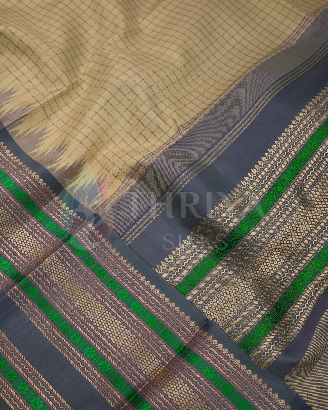 Close-up of beige silk fabric and intricate green zari border – premium handwoven silk saree by Thriya Silks