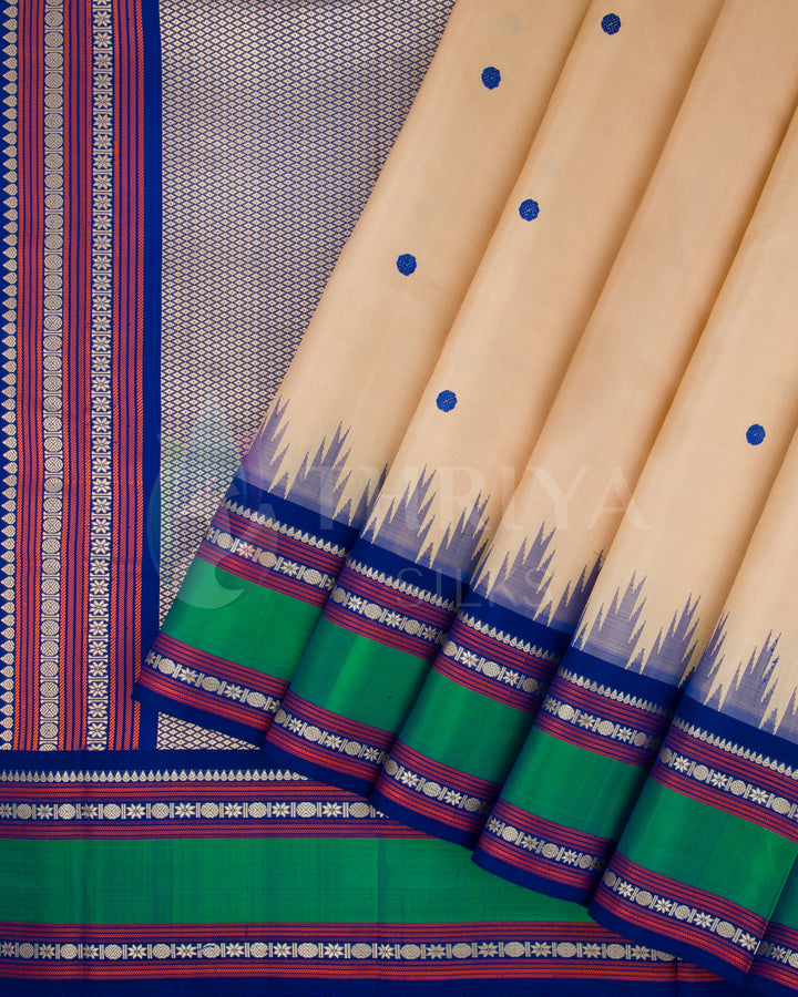 Beige silk saree with vibrant green border and rich blue zari work, from Thriya Silks