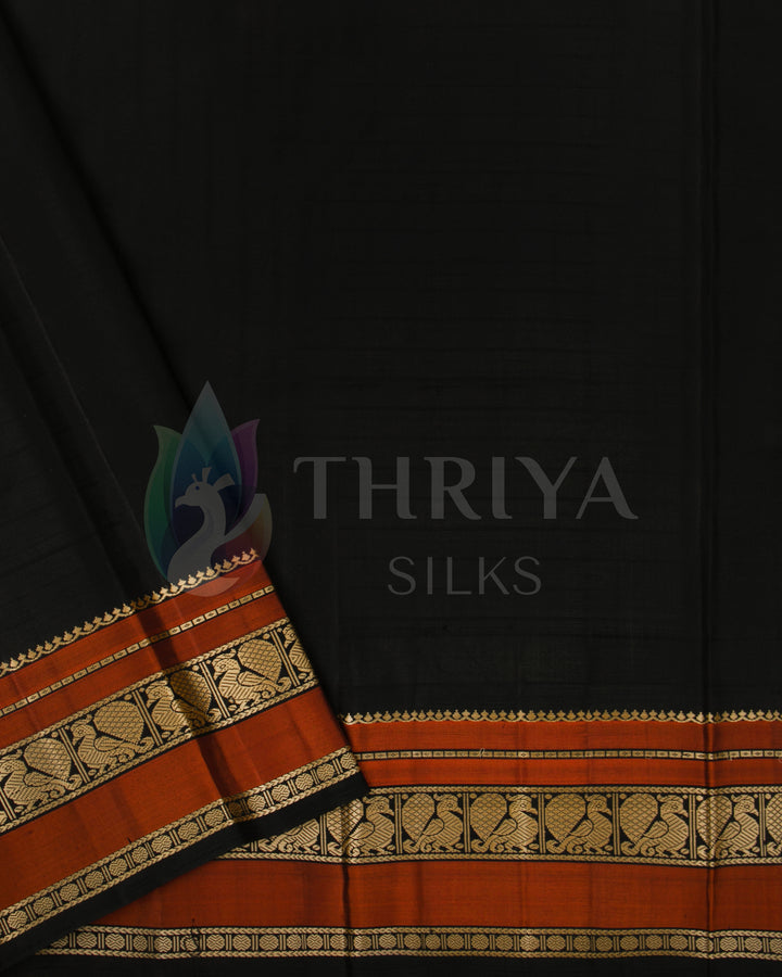 Contrasting black blouse piece with rust-orange and gold zari border, paired with beige saree from Thriya Silks