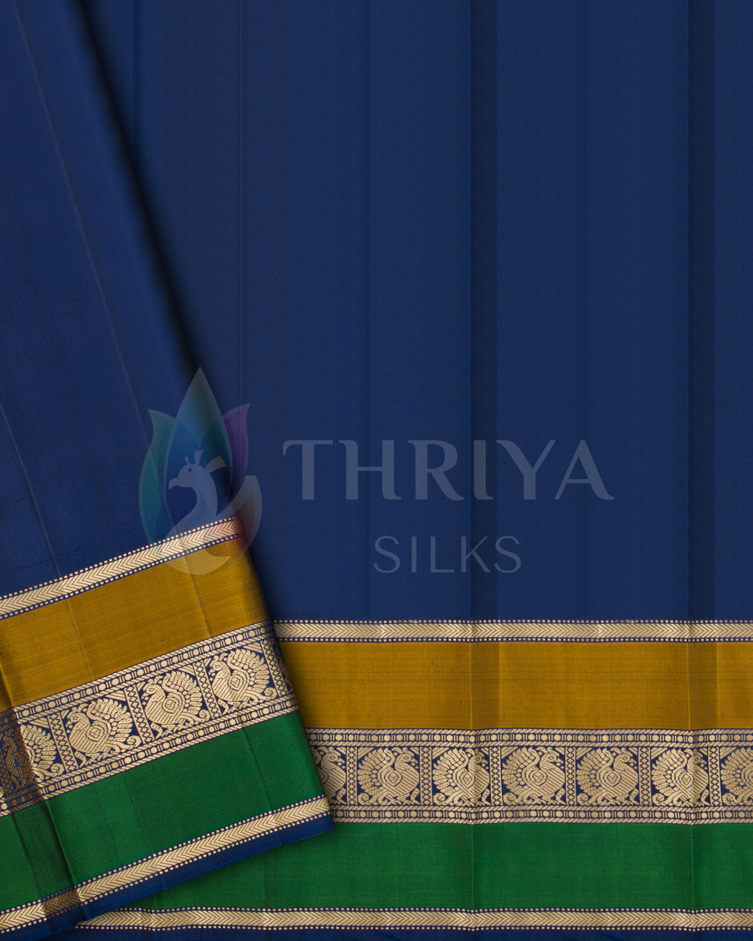 Navy blue silk blouse piece with gold and green zari border, complementing cream saree, from Thriya Silks