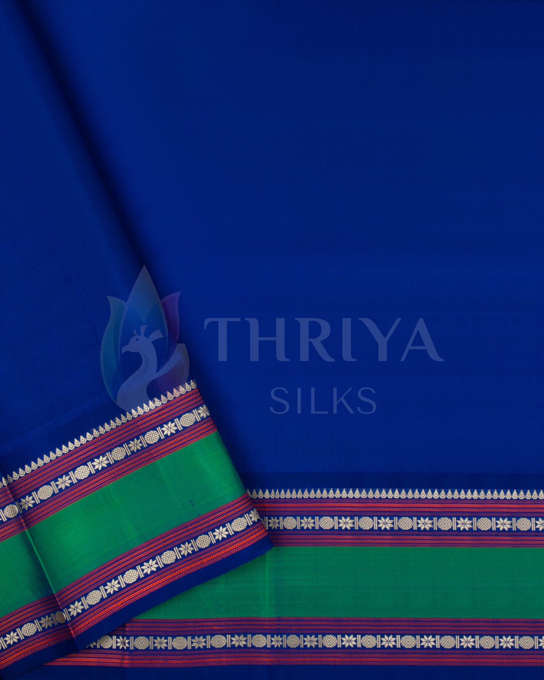 Plain royal blue blouse with green and zari border, complements beige saree from Thriya Silks