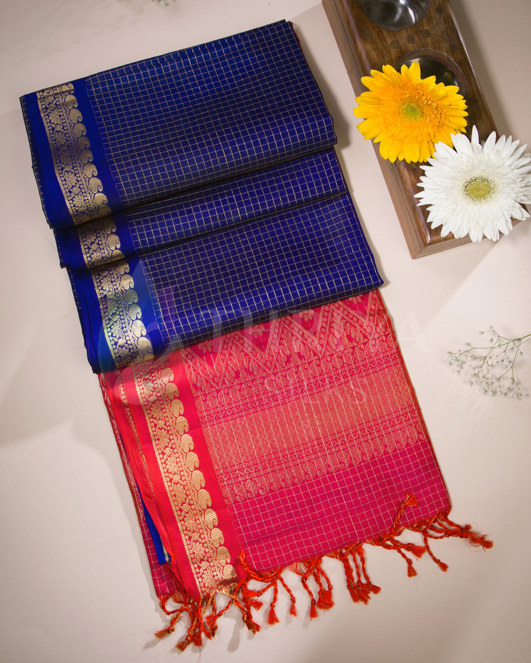 Blue and red Kanjivaram silk saree styled with floral elements in a lifestyle setup
