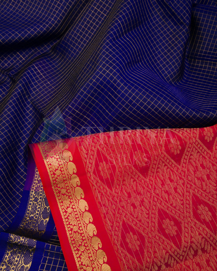 Close-up view of rich blue silk saree with intricate golden checks and red zari border