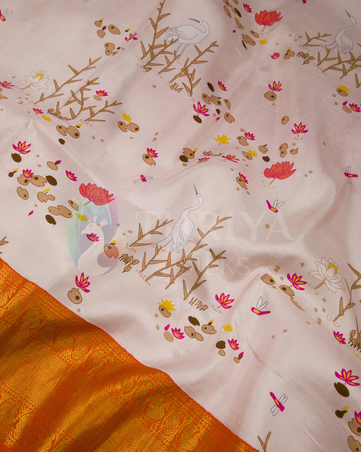  Close-up of the saree body featuring graceful bird and lotus motifs on pastel pink silk fabric.