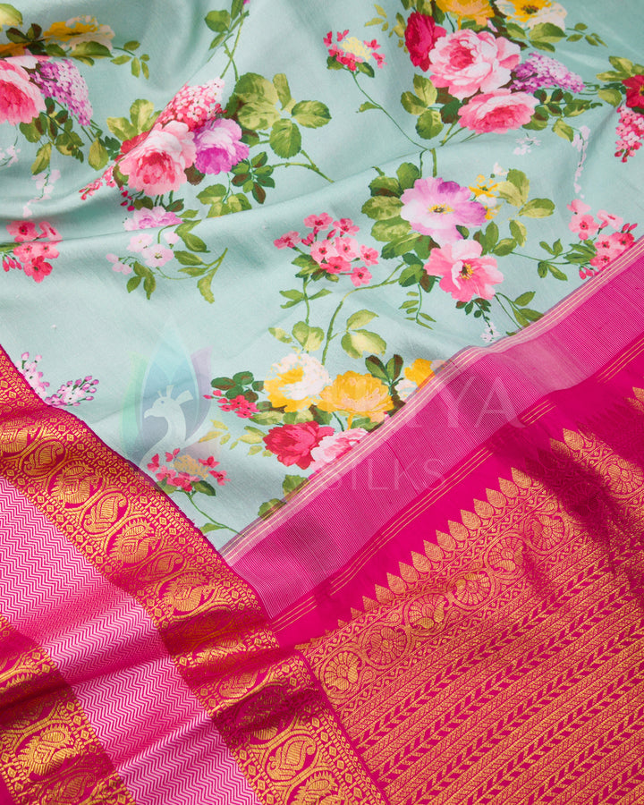 Close-up of pink and gold zari detailing paired with floral prints on mint green silk fabric