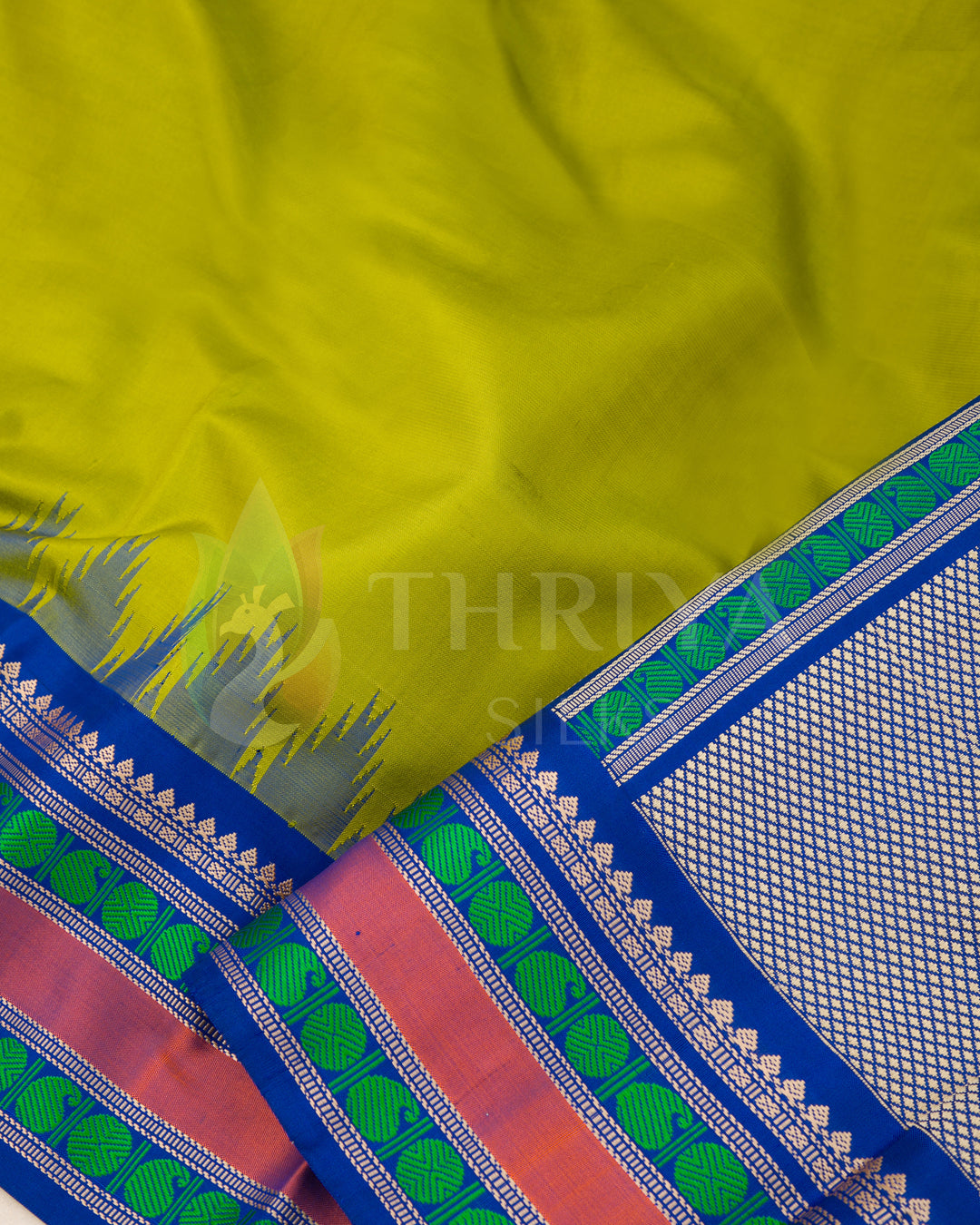  Close-up of green silk saree highlighting intricate zari border with pink, green, and blue woven textures.