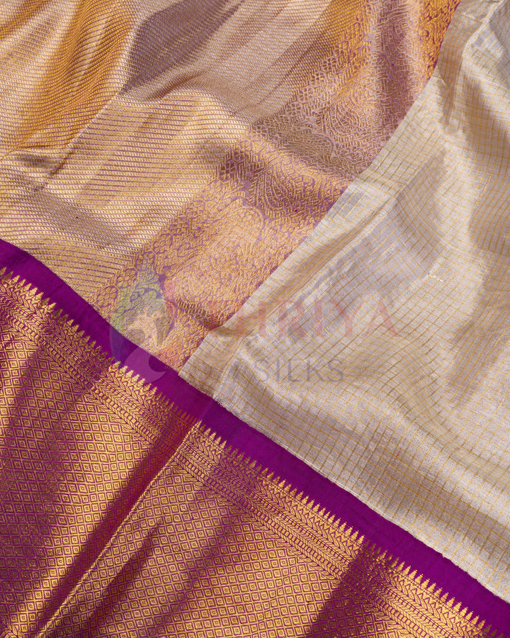 Close-up of cream Kanjivaram silk saree highlighting intricate golden weave and purple zari border