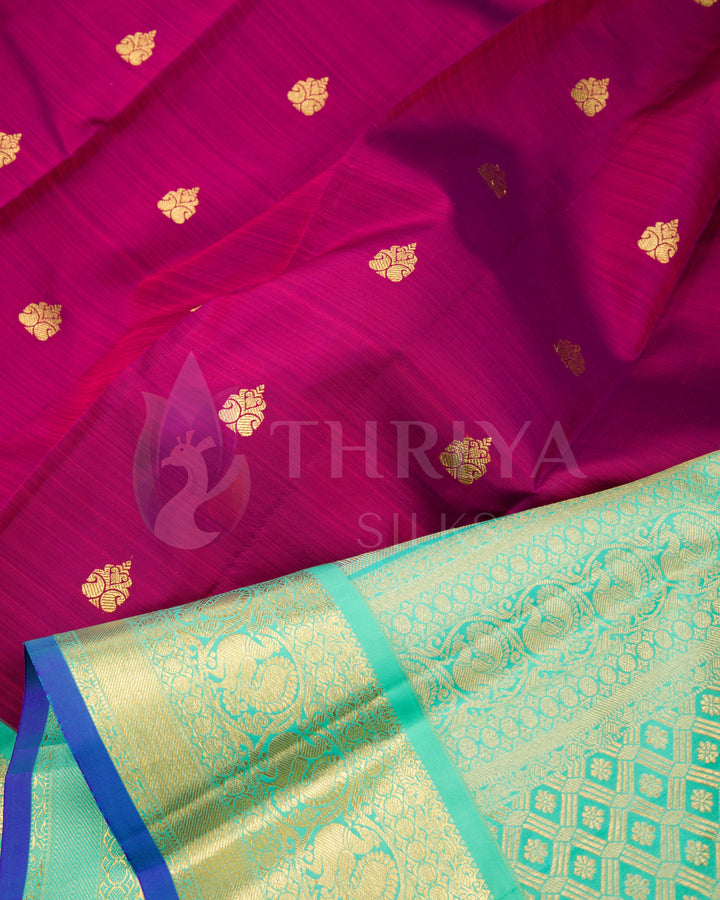Close-up of magenta silk saree with golden leaf motifs and richly woven green zari pallu