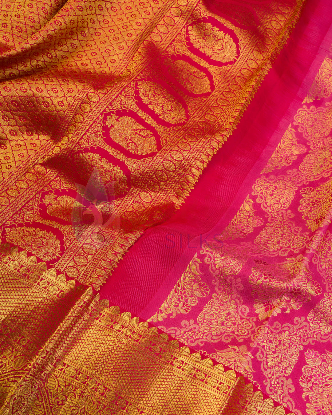 Close-up of rust Kanjivaram silk saree pallu with intricate gold zari motifs and pink border