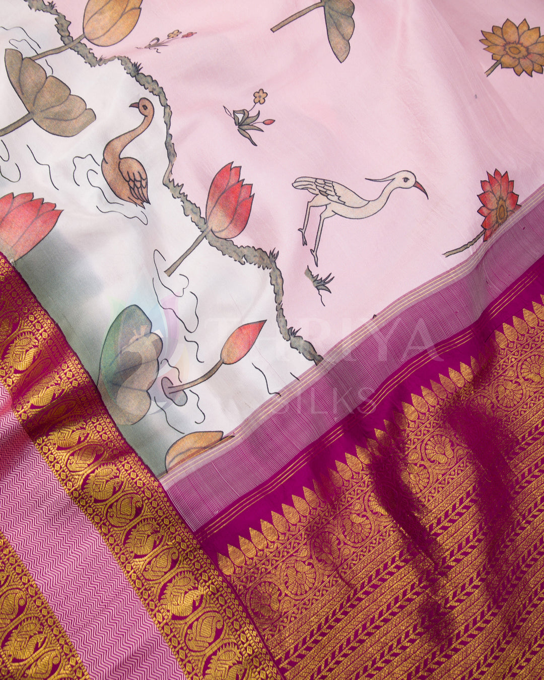 Close-up of detailed lotus, bird, and swan motifs along with traditional zari border on silk fabric.
