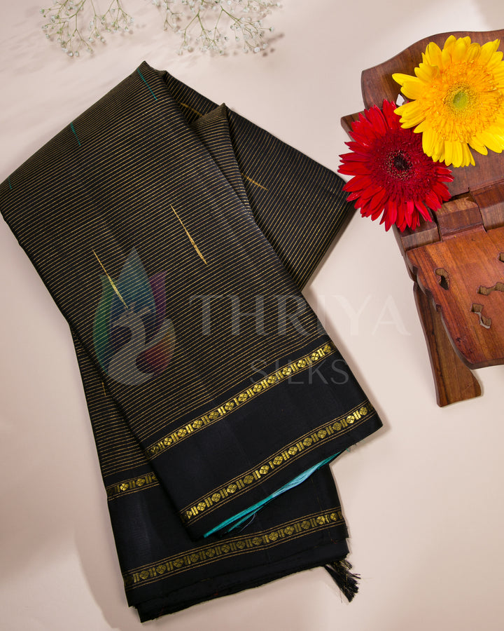 Folded Thriya silk saree in black and turquoise with floral flat lay setup for festive styling
