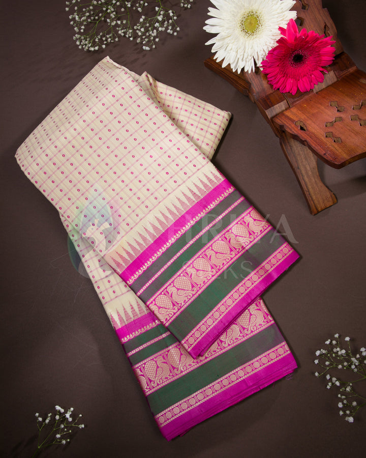 Folded cream silk saree with olive green and pink zari border, styled with flowers, from Thriya Silks