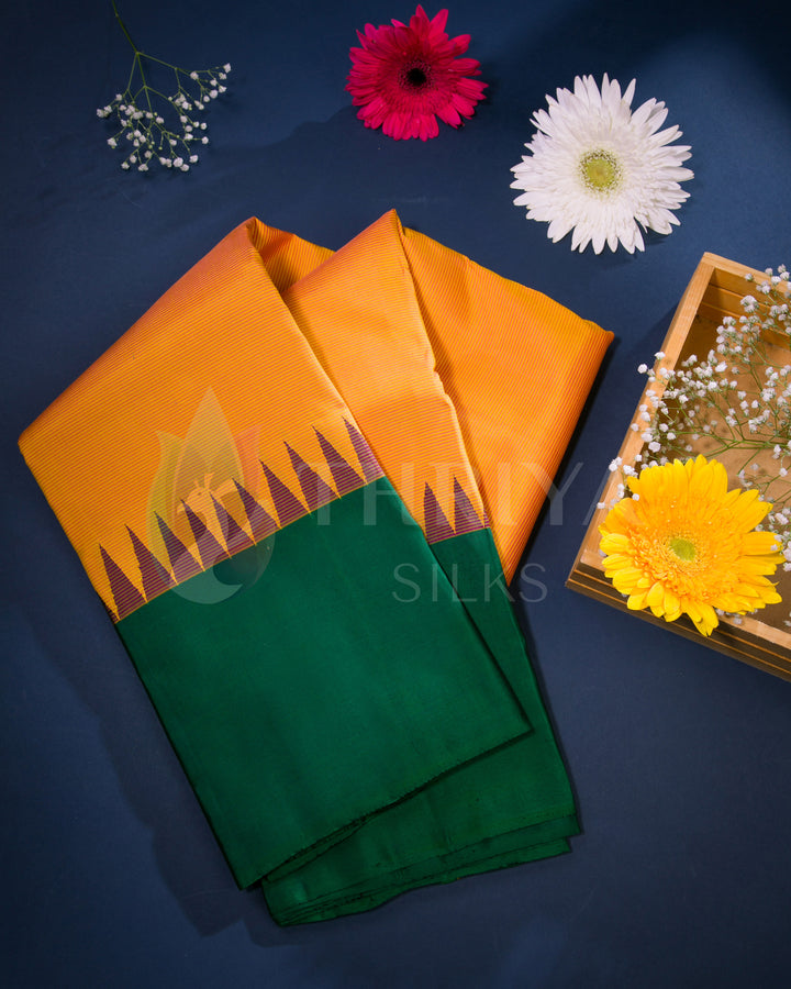 Folded green and orange silk saree displayed with colorful flowers, from Thriya Silks