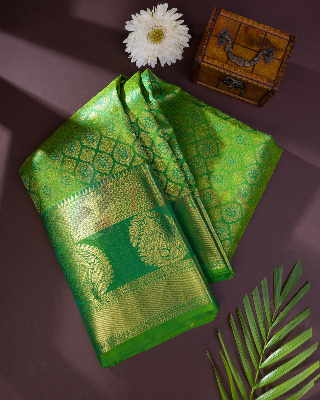 Folded green Kanjivaram silk saree with golden zari pallu, perfect for gifting or special occasions