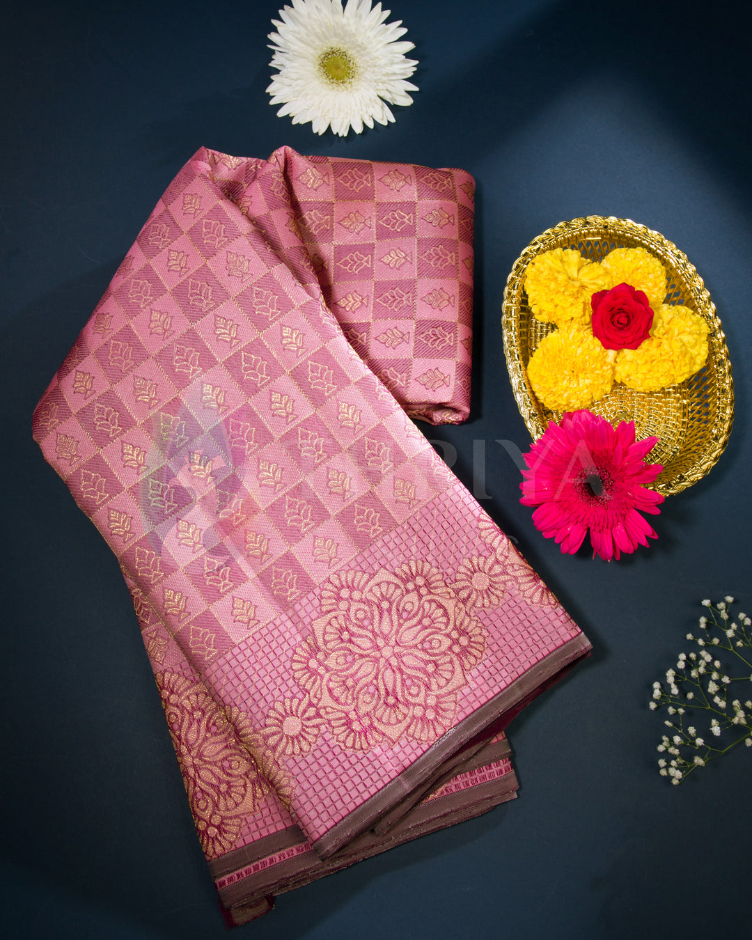 Folded pink and brown Kanjivaram silk saree with golden jacquard work styled with flowers