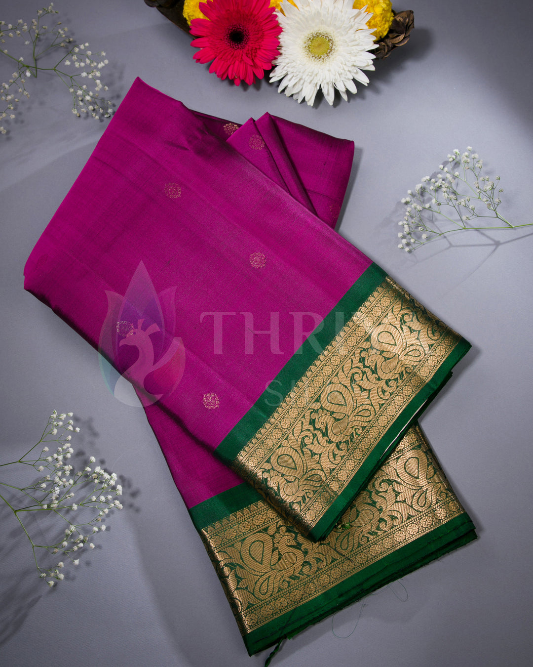 Folded purple and green Kanjivaram saree styled with flower decor