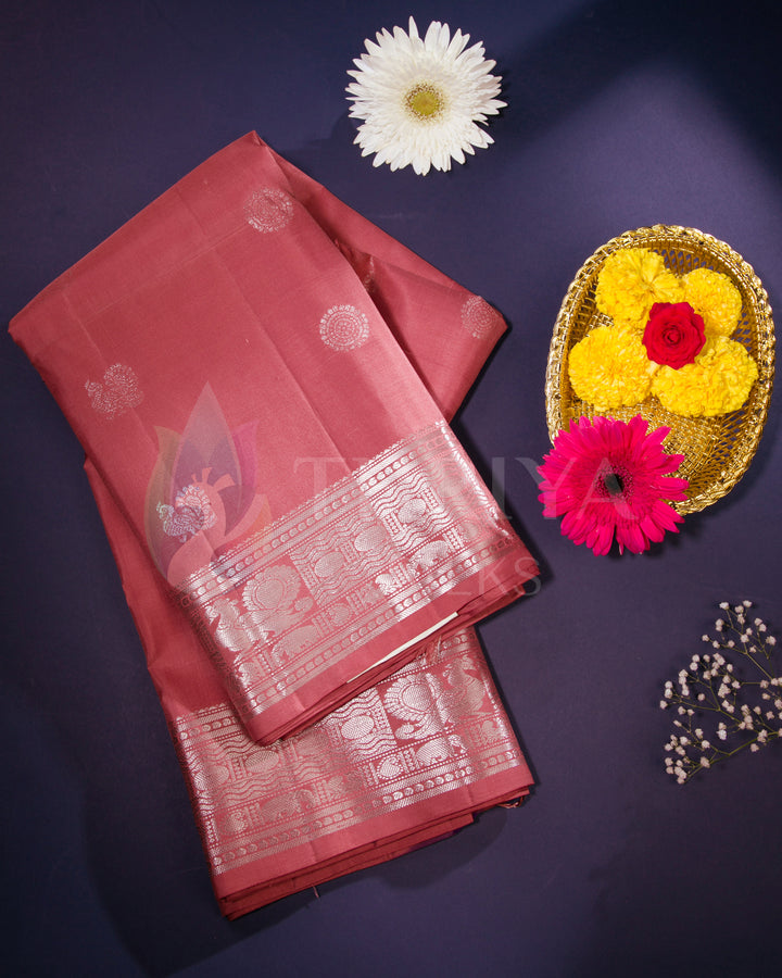 Folded rose pink Kanjivaram saree with silver zari border, styled with flowers