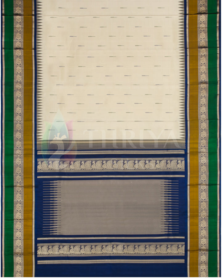 Full layout of cream silk saree with blue pallu, green and gold borders, and subtle woven motifs, Thriya Silks