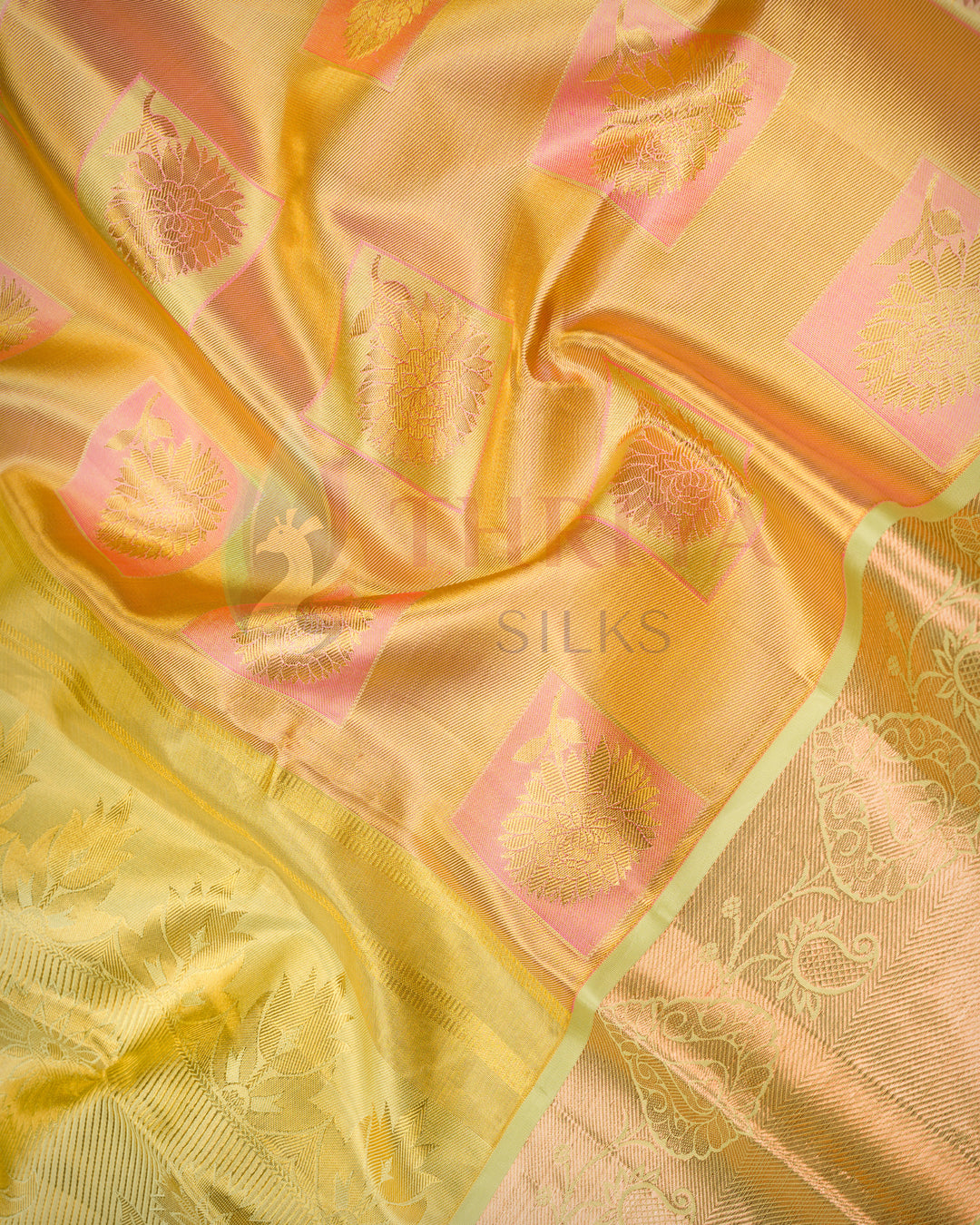 Close-up view of golden yellow Kanjivaram silk saree highlighting detailed green zari work and elegant pattern.