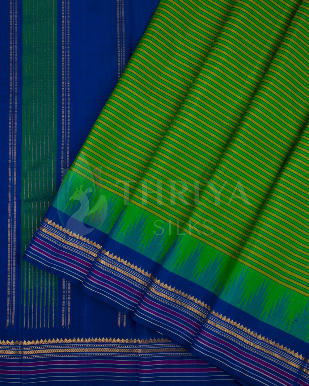 Green and blue silk saree showing pleats with intricate golden and pink border design, from Thriya Silks