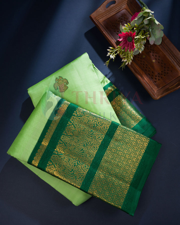 Light green Kanchipuram silk saree with gold floral buttas and intricately woven zari pallu