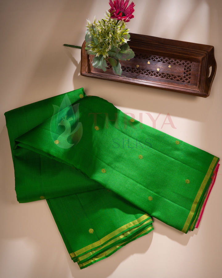 Bright green Kanchipuram silk saree with gold buttas and pink contrast border